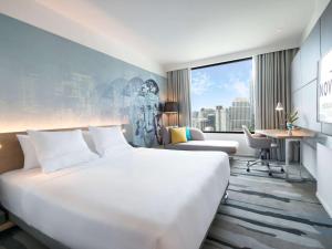 曼谷诺富特曼谷素坤逸4酒店 的酒店客房设有一张白色大床和一张书桌