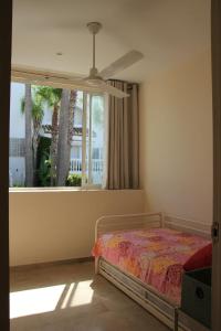EsteponaChalet adosado en urbanización con piscina的一间卧室设有一张床和一个窗口