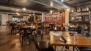 New ProvidenceThe Hub Murray Hill, BW Premier Collection的一间带木桌椅的餐厅和一间酒吧