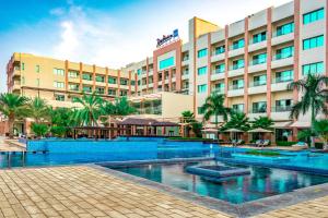 索哈尔Radisson Blu Hotel & Resort, Sohar的大楼前设有游泳池的酒店