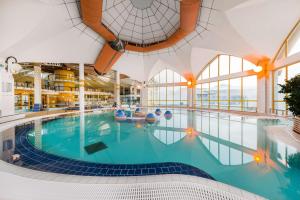 萨尔瓦尔Park Inn by Radisson Sarvar Resort & Spa - All Inclusive的一座大型室内游泳池,位于一座带窗户的建筑中
