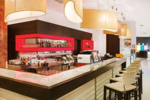 萨尔瓦尔Park Inn by Radisson Sarvar Resort & Spa - All Inclusive的一间酒吧,餐厅里设有红色橱柜和椅子