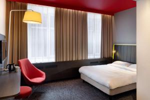 塔林塔林雷迪森中心公园酒店的配有一张床和一把椅子的酒店客房
