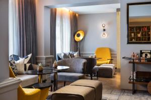 伦敦Holmes Hotel London的客厅配有沙发、椅子和桌子