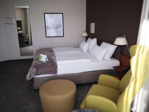 茨维考茨维考第一酒店的配有一张床和一把椅子的酒店客房