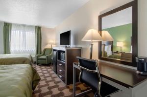 RussellQuality Inn的酒店客房配有一张床和一张带镜子的书桌
