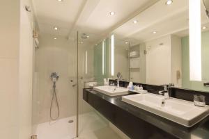 阿姆斯特丹Radisson Blu Hotel, Amsterdam City Center的一间带两个盥洗盆和淋浴的浴室