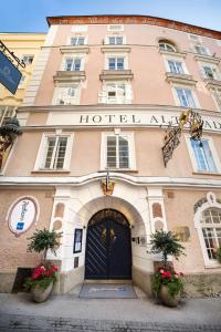萨尔茨堡老生蓝色丽笙酒店的一座建筑,前方有鲜花,有酒店入口