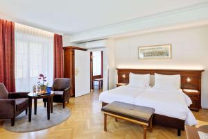 萨尔茨堡老生蓝色丽笙酒店的酒店客房带一张床、一张桌子和椅子