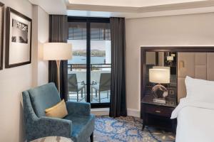 迪拜迪拜德伊勒河丽笙酒店的酒店的客房 - 带一张床、椅子和窗户