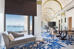 迪拜迪拜德伊勒河丽笙酒店的客厅配有桌椅和电视。