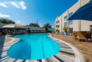 卢萨卡卢萨卡丽笙酒店的一座大型蓝色游泳池,位于大楼旁边