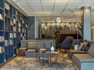 阿兰达斯德哥尔摩阿兰达阿兰迪亚丽笙酒店的拥有蓝色墙壁、沙发和桌子的图书馆