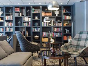 阿兰达斯德哥尔摩阿兰达阿兰迪亚丽笙酒店的客厅配有沙发、椅子和书架
