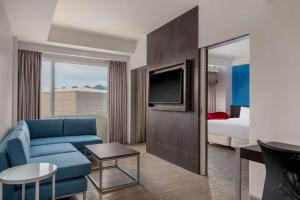 伊洛伊洛Park Inn By Radisson Iloilo的酒店客房配有蓝色的沙发和床。