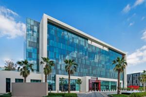 迪拜Radisson RED Dubai Silicon Oasis的一座棕榈树的办公楼