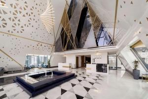 利雅德Radisson Blu Hotel Riyadh Qurtuba的大堂设有大壁炉和大型天花板。