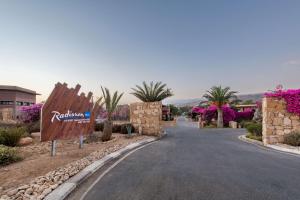 塔哈佐特Radisson Blu Resort Taghazout Bay Surf Village的中间有标志的度假胜地的一条道路