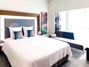 富查伊拉诺富特富查伊拉酒店的酒店客房,设有两张床和一张沙发