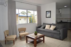伊瓜苏港Aires de Cataratas的客厅配有沙发和桌子