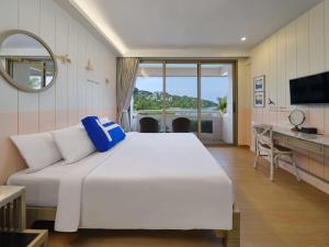芭东海滩HOMM Bliss Southbeach Patong的卧室配有一张白色大床和一张书桌