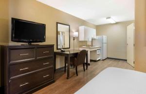 罗阿诺Extended Stay America Select Suites - Roanoke - Airport的一间带书桌和电视的客房以及一间卧室