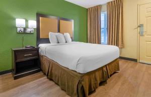 罗阿诺Extended Stay America Select Suites - Roanoke - Airport的一张大床,位于带绿色墙壁的房间
