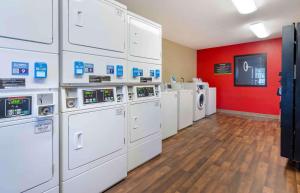 罗阿诺Extended Stay America Select Suites - Roanoke - Airport的洗衣房配有白色洗衣机和红色墙壁
