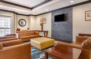 金伍德休斯顿-金伍德烛木套房酒店的客厅配有皮革家具和平面电视