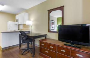 土桑亚美利卡延住酒店 - 图森 - 格兰特路的酒店客房配有书桌和电视。