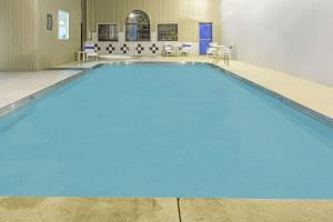 加利波利斯Super 8 by Wyndham Gallipolis Pt Pleasant Area的室内的蓝色海水游泳池