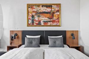 海宁艾德贝斯特韦斯特优质酒店的卧室配有一张床,墙上挂有绘画作品