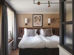 斯德哥尔摩Hotel Frantz, WorldHotels Crafted的一间卧室配有两张带白色毯子和枕头的床