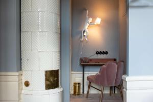 斯德哥尔摩Hotel Frantz, WorldHotels Crafted的一间房间,墙上有一张桌子和一尊女人的雕像