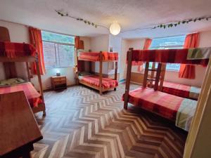 巴尼奥斯Hostel Plantas y Blanco的客房设有两张双层床和一张桌子。