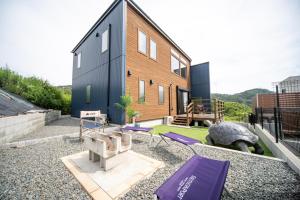 KusumotoAwaji Seaview Resort in Nojima的一座带紫色垫子后院的房子