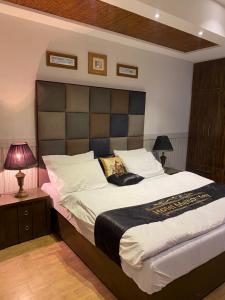 伊斯兰堡Hotel Milton的一间卧室配有一张大床和大床头板