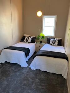 WhangaroaFISHERMANS’DELIGHT的小型客房 - 带2张床和窗户