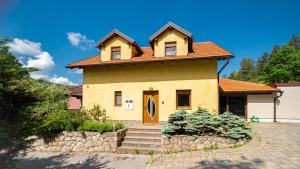 弗济内Kuća za odmor KRISTINA的黄色的房子,有橙色的门和楼梯
