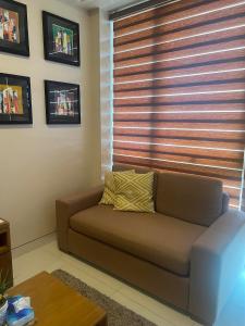 Punta EngañoC2 Mactan的客厅里设有一张棕色沙发,配有窗户