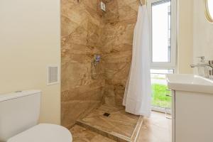 帕兰加Seaside apartments 2的带淋浴、卫生间和盥洗盆的浴室