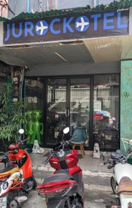 芭堤雅市中心Jurockotel的停在商店前的一组摩托车