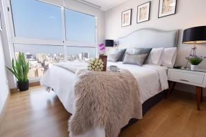 利马Skyliving Towers Apartments - Perú的卧室配有白色的床和大窗户