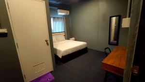 芭堤雅市中心Jurockotel的一间小卧室,配有一张床和镜子