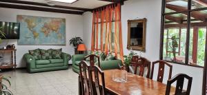 圣何塞Casa Kibi Kibi的一间带桌子和绿色沙发的用餐室