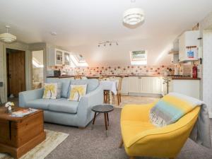 洛斯特威希尔The Hayloft的一间带蓝色沙发的客厅和一间厨房