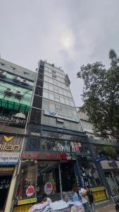 达卡Hotel Prime Inn Mirpur 10的前面有一间商店的高楼