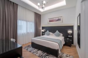 迪拜Rose Garden Hotel Apartments - Al Barsha, Near Metro Station的一间卧室设有一张大床和一个窗户。