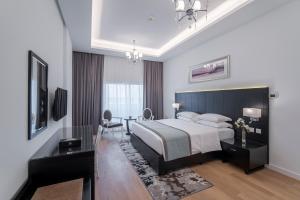 迪拜Rose Garden Hotel Apartments - Al Barsha, Near Metro Station的一间卧室配有一张特大号床和一张书桌