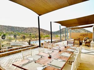 KhorixasLodge Damaraland的庭院内的大型用餐室配有桌椅